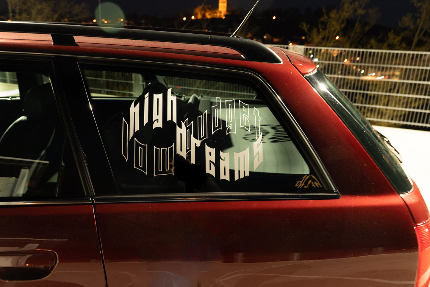 Rechteckiger Autosticker mit dem Schriftzug „low budget, high dreams“, wählbar in 25×17,1 cm oder 40×27,4 cm; frisch produziert, aus langlebiger Oracal/Orafol-Vinylfolie, selbstklebend, ideal für Tuning-Fans und Auto-Enthusiasten.