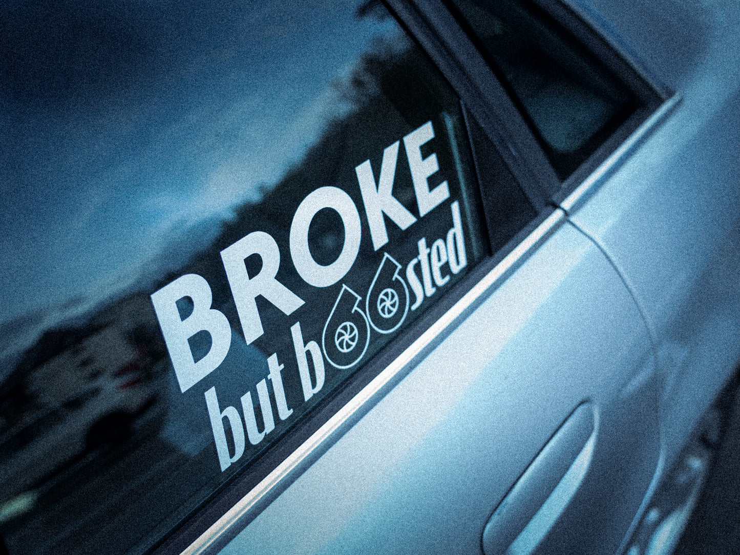 Rechteckiger Autosticker mit dem Schriftzug „broke, but boosted“, wählbar in 15×6,8 cm oder 25×11,3 cm; frisch produziert, aus langlebiger Oracal/Orafol-Vinylfolie, selbstklebend, ideal für Tuning-Fans und Auto-Enthusiasten.