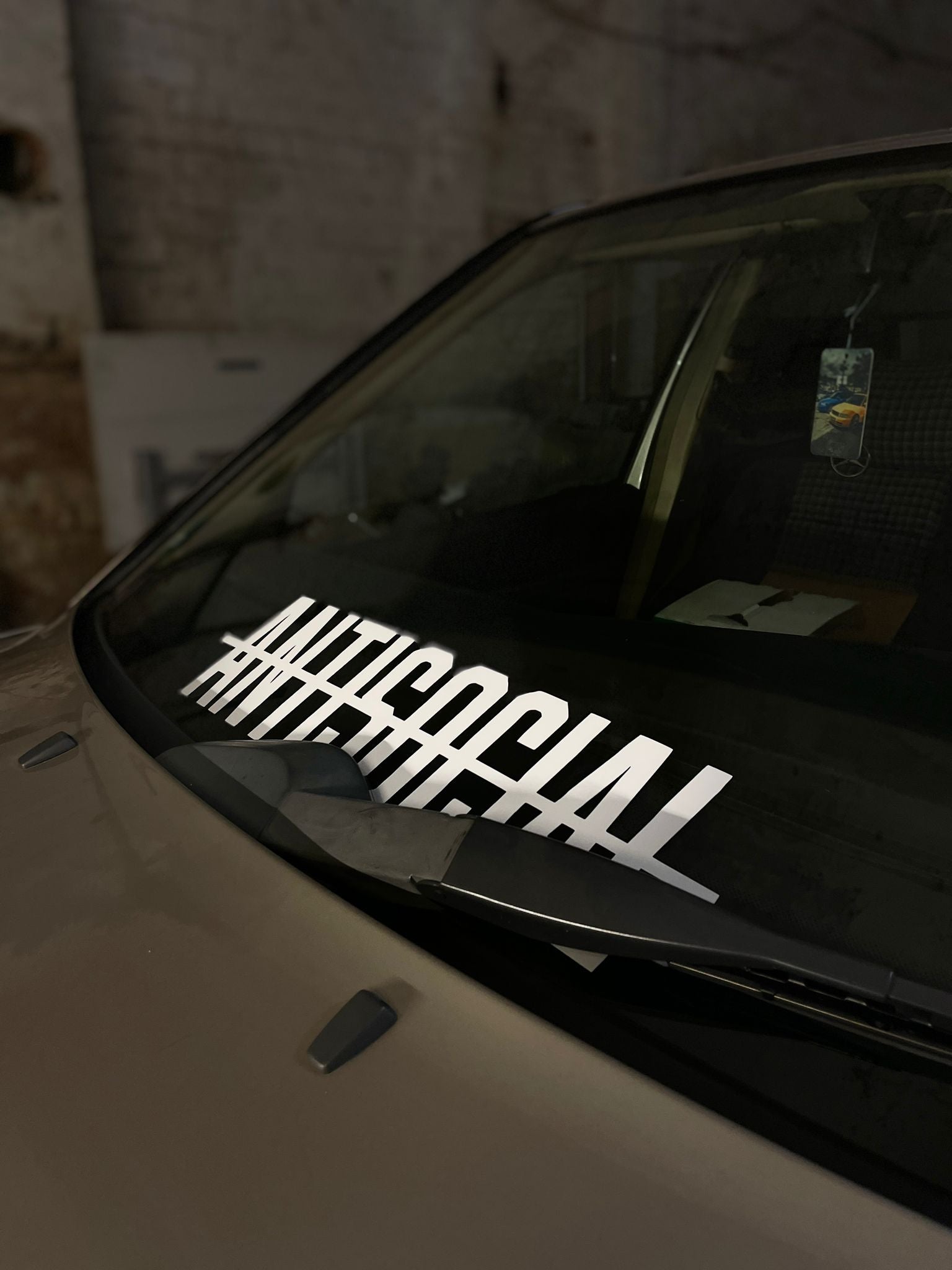 Antisocial Tuning Autoaufkleber - Beispielfoto auf einem Auto, Der Sticker ist in Farbe weiß gläzend abgebilldet, erstellt von der Marke delusional