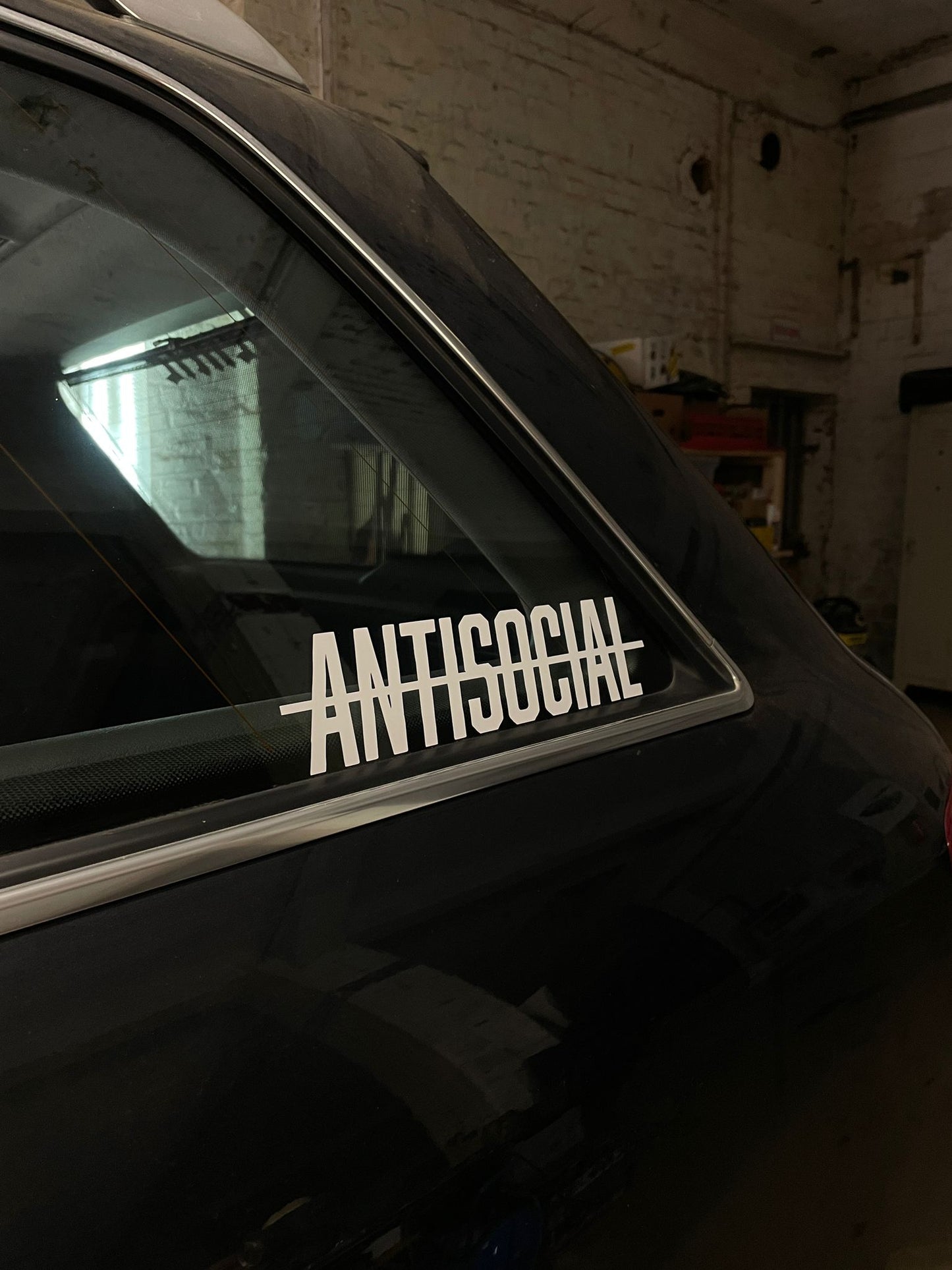 Antisocial Tuning Autoaufkleber - Beispielfoto auf einem Auto, Der Sticker ist in Farbe weiß gläzend abgebilldet, erstellt von der Marke delusional